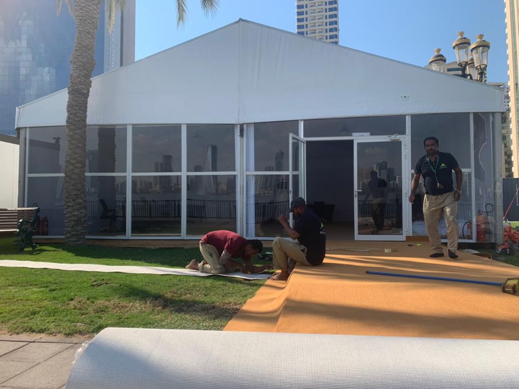 Workers installing glass panel tent by Mahraj Industries at a UAE event location